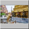 Bangkok - Wat Phra Kaeo, ein mythisches Wesen (Kinara) sowie D&auml;monen, die einen Chedi st&uuml;tzen, links das Dach der k&ouml;niglichen Bibliothek