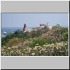 Petchaburi - Blick vom "Bergschloss" auf die Nachbarh&uuml;gel (u.a. alte Chedis und rote Pagode), vorne wei&szlig; bl&uuml;hende Frangipani-B&auml;ume